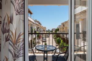 a balcony with a table and chairs and a view of a street at Dora Pool Studios by Konnect,150m from the Beach in Agios Georgios