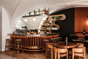 a restaurant with a bar with chairs and tables at The Originals Boutique, Hôtel Le Lion, Clermont-Ferrand in Clermont-Ferrand