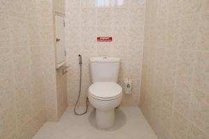 a bathroom with a toilet with a sign on the wall at House Number 3 in Phitsanulok +23 photos