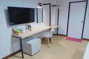 a desk with a television on top of it in a room at House Number 3 in Phitsanulok