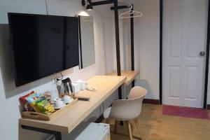a room with a desk with a television and a chair at House Number 3 in Phitsanulok