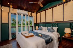 a bedroom with a large bed and a large window at Boats N Beds - Alleppey Houseboats - Alleppey Boat House - Luxury Premium Houseboats in Alleppey