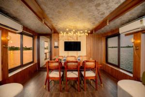 a dining room with a table and chairs and a tv at Boats N Beds - Alleppey Houseboats - Alleppey Boat House - Luxury Premium Houseboats in Alleppey +20 photos