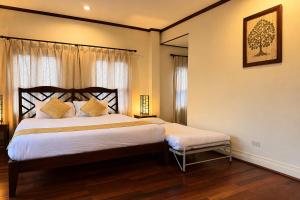 a bedroom with a large bed with a wooden headboard at Luang Prabang Legend Hotel in Luang Prabang