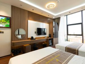 a hotel room with two beds and a television at Viet Phuong Center Hotel in Ninh Binh