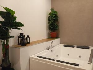 a white bath tub with two plants in a room at B&B il Palazzo Cirella in Cirella
