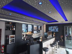 a bar with a blue ceiling and stools at City Hotel in Rheinfelden