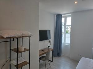 a bedroom with a bed and a desk with a television at City Hotel in Rheinfelden