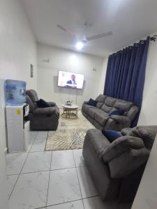 a living room with couches and a flat screen tv at New Barcelona in Mombasa