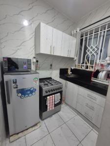 a kitchen with a refrigerator and a stove in it at New Barcelona in Mombasa