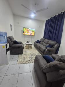 a living room with two couches and a tv at New Barcelona in Mombasa