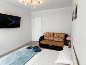 a living room with a bed and a couch at Grand Angleterre Penthouse in Astana