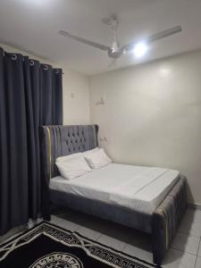 a bed in a room with a blue curtain at New Barcelona in Mombasa