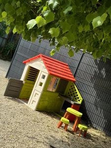 a small house with a red roof and two chairs at Gîte La Patouille in Amboise