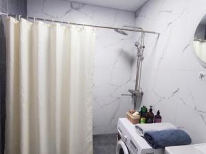 a bathroom with a shower curtain and a sink at Grand Angleterre Penthouse in Astana