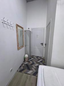 a white hallway with a door and a mirror at Хостел in Astana