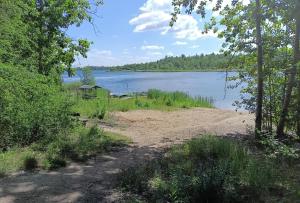 a dirt trail next to a lake with trees at Fewo Zur Windmühle in Pegau