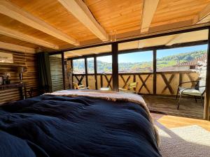 a bedroom with a large bed and a large window at Le Soleilho in Figeac