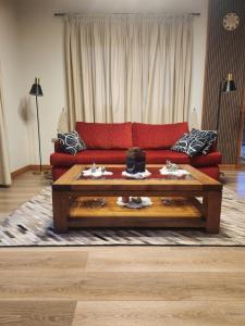 a living room with a red couch and a coffee table at Apart bio bio in Concepción