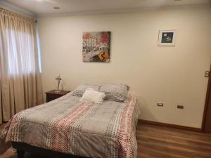 a bedroom with a bed with a pillow on it at Apart bio bio in Concepción