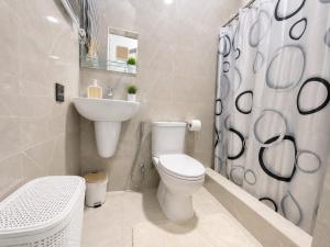 a white bathroom with a toilet and a sink at Naso Luxe Homes in Sakumona +5 photos