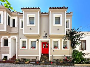 a building with a red door on a street at 19 Oda Bozcaada in Çanakkale