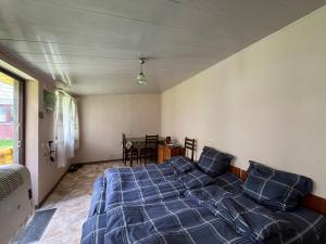 a bedroom with a bed with blue sheets and a table at Maia's Guest House Gergeti in Kazbegi