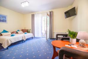 a hotel room with two beds and a table at Las i Morze - Dźwirzyno in Dźwirzyno +62 photos