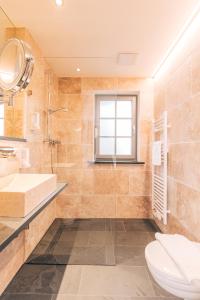 紐倫堡的住宿－孔斯特卡緹爾比奧酒店，一间带卫生间、水槽和镜子的浴室