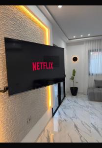 a television on a brick wall in a living room at Villa Tanit in Taguermess
