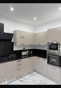 a white kitchen with white cabinets and appliances at Villa Tanit in Taguermess