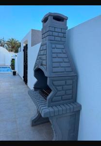 a brick fireplace sitting on the side of a building at Villa Tanit in Taguermess