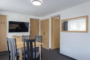 a dining room with a table and chairs and a television at Willa Mak in Krynica Zdrój +180 photos