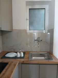 a kitchen counter with a sink and a window at Bel Air Rooms in Himare