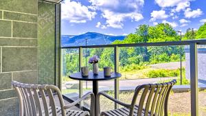 a table and two chairs on a balcony with a view at Mountain Horizon Valley z basenami, saunami i strefą fitness by Royal Aparts in Szklarska Poręba