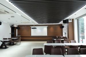 a conference room with tables and chairs and a screen at Viet Phuong Center Hotel in Ninh Binh