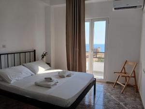 a bedroom with a bed with a view of the ocean at Bel Air Rooms in Himare