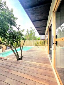 a wooden walkway leading to a house with a pool at Wadi Residence in General Luna