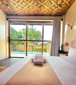 a bedroom with a bed and a large window at Wadi Residence in General Luna