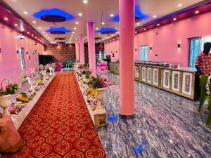 a banquet hall with a long aisle with flowers at Aman Convention in Chāndbāli