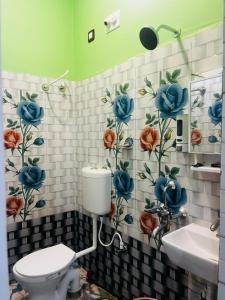 a bathroom with a toilet and flowers on the wall at Aman Convention in Chāndbāli
