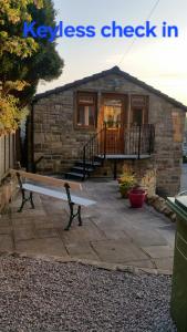 a stone house with a bench in front of it at Stone Eater in Marsden