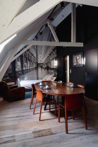 a dining room with a table and chairs and a bed at Les Chambres du Vaudeville in Brussels