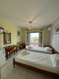 a hotel room with two beds and a balcony at Orama Hotel in Sígrion +25 photos