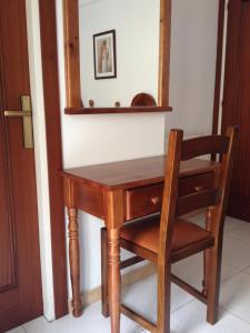 a wooden desk with a chair and a mirror at Hotel Beri - Can Llançà in Llança