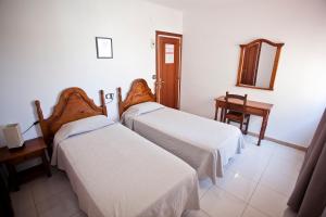 a room with two beds and a mirror at Hotel Beri - Can Llançà in Llança