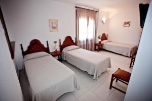 a room with three beds and a window at Hotel Beri - Can Llançà in Llança