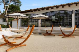 a group of chairs and umbrellas on a patio at Wyndham Mallorca Portocolom Resort in Portocolom