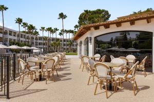 a row of tables and chairs on a patio at Wyndham Mallorca Portocolom Resort in Portocolom +124 photos