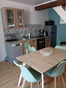 a kitchen with a wooden table and blue chairs at Les Reflets de Meuse in Revin